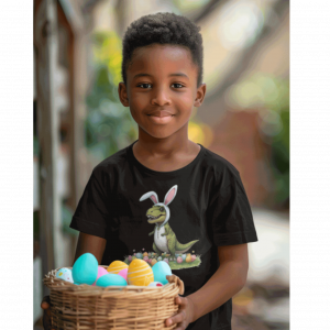 White T‑shirt with a cartoon T‑rex wearing bunny ears standing on grass surrounded by colorful Easter eggs