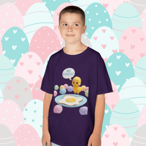 Child wearing a purple T‑shirt with a cartoon chick looking at a fried egg and saying “Bro! Is That You?” surrounded by colorful Easter eggs