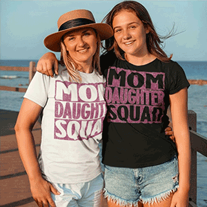 Mother and daughter wearing matching “Mom Daughter Squad” T‑shirts outdoors
